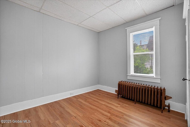 329 E Main St, Amsterdam, NY 12010 - empty room featuring radiator, a paneled ceiling, and light wood finished floors