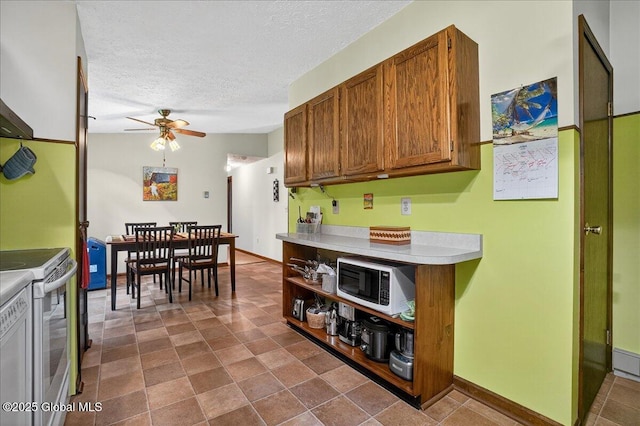 585 Logtown Rd, Glen, NY 12072 - kitchen featuring white appliances, ceiling fan, a textured ceiling, light countertops, and brown cabinetry