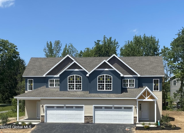 1E Brison St, North Greenbush, NY 12180 - view of front facade featuring asphalt driveway, a shingled roof, an attached garage, and stone siding