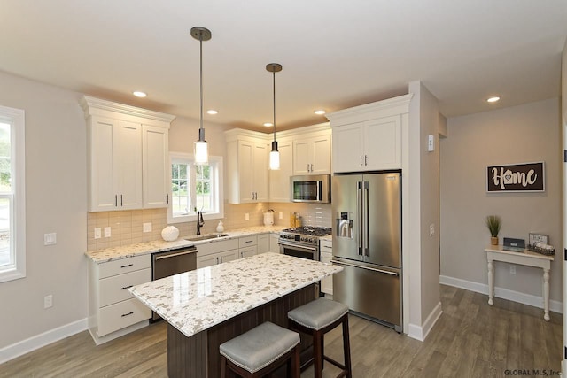 1E Brison St, North Greenbush, NY 12180 - kitchen featuring premium appliances, decorative backsplash, wood finished floors, white cabinets, and recessed lighting