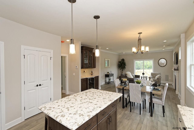 1E Brison St, North Greenbush, NY 12180 - kitchen featuring dark brown cabinetry, light wood-style flooring, beverage cooler, glass insert cabinets, and ornamental molding