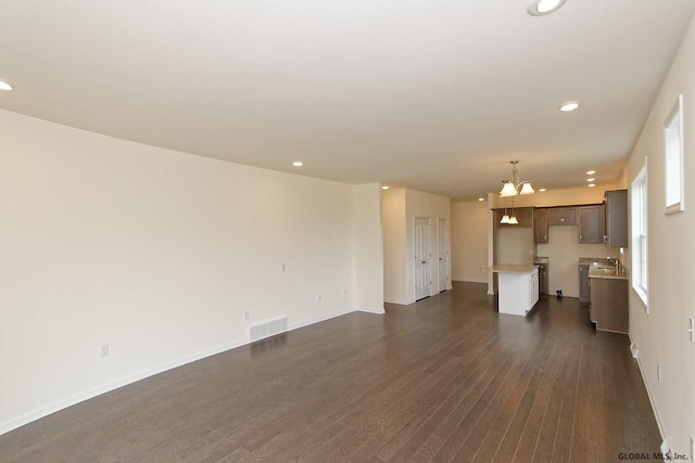 1E Brison St, North Greenbush, NY 12180 - unfurnished living room with a chandelier, dark wood-style floors, and recessed lighting