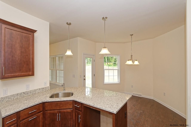 1E Brison St, North Greenbush, NY 12180 - kitchen with a peninsula, dark wood-style floors, light stone countertops, and decorative light fixtures