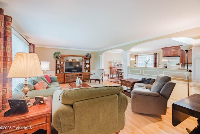 34 Aspen Rd, Colonie, NY 12110 - living room with decorative columns, arched walkways, crown molding, and light wood finished floors