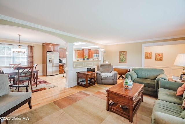 34 Aspen Rd, Colonie, NY 12110 - living room featuring ornate columns, crown molding, arched walkways, a chandelier, and light wood-type flooring