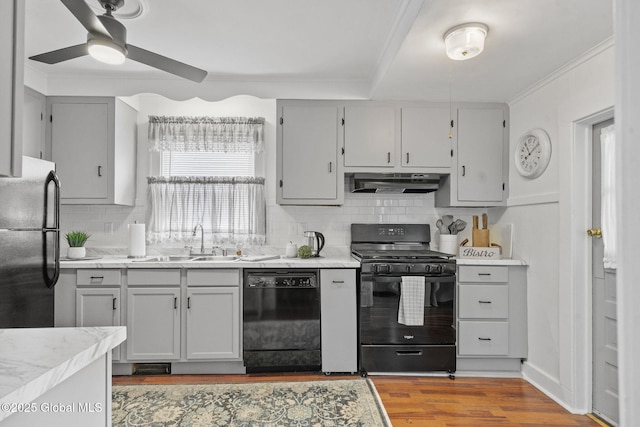 2730 Denver Ave, Rotterdam, NY 12306 - kitchen with black appliances, under cabinet range hood, wood finished floors, backsplash, and light countertops