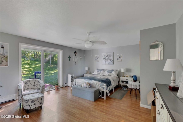 3140 State Route 5s, Danube, NY 13339 - bedroom featuring light wood-style floors, ceiling fan, and a baseboard heating unit
