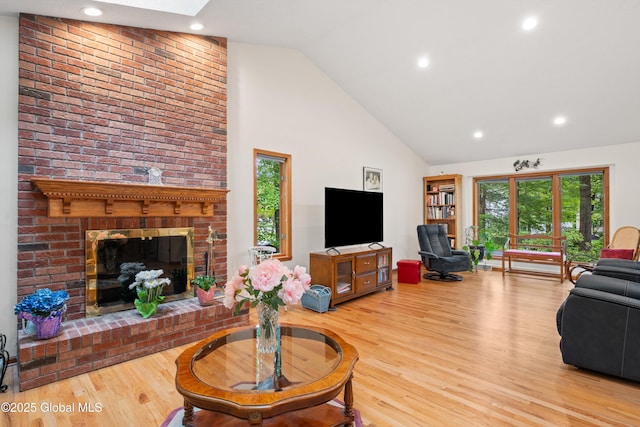 69 Deer Run Holw, Halfmoon, NY 12065 - living area with high vaulted ceiling, wood finished floors, a fireplace, recessed lighting, and a skylight