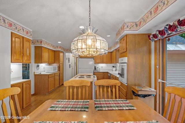 69 Deer Run Holw, Halfmoon, NY 12065 - kitchen featuring white appliances, a chandelier, light wood-type flooring, light countertops, and hanging light fixtures