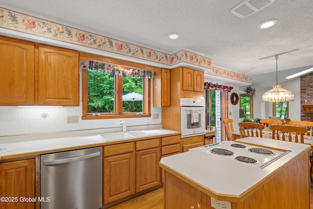 69 Deer Run Holw, Halfmoon, NY 12065 - kitchen with stainless steel dishwasher, white oven, a textured ceiling, stovetop, and light countertops