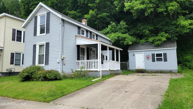 52 Hancock St, Fort Plain, NY 13339 - view of front of property featuring covered porch, a front yard, a chimney, and an outdoor structure