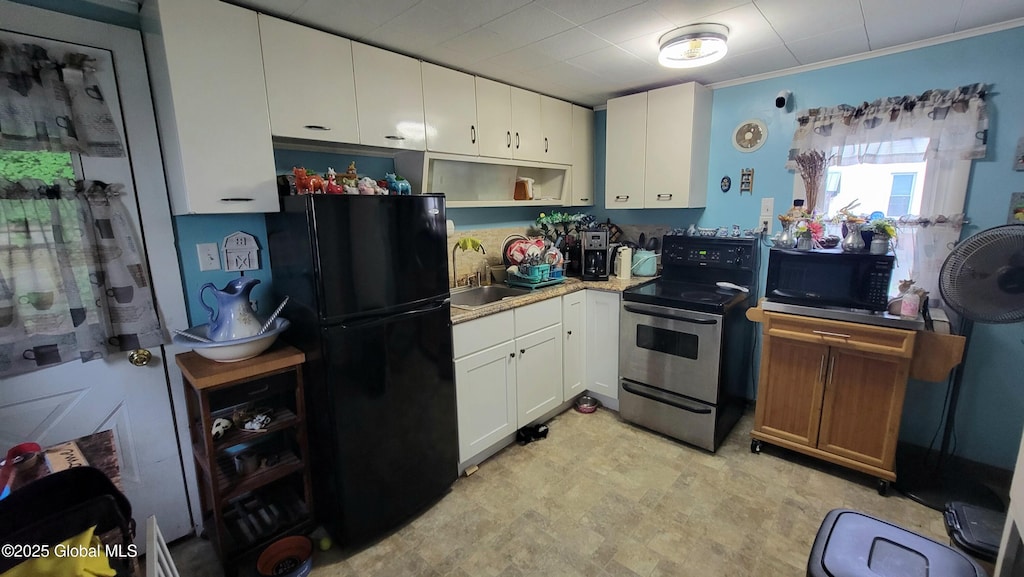 52 Hancock St, Fort Plain, NY 13339 - kitchen with stainless steel range with electric stovetop, freestanding refrigerator, white cabinets, light countertops, and open shelves