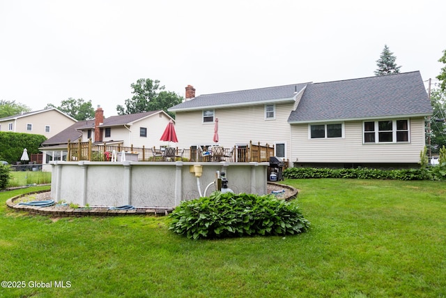 46 Cindy Crest Dr, Rotterdam, NY 12306 - back of property featuring a yard, an outdoor pool, and a shingled roof