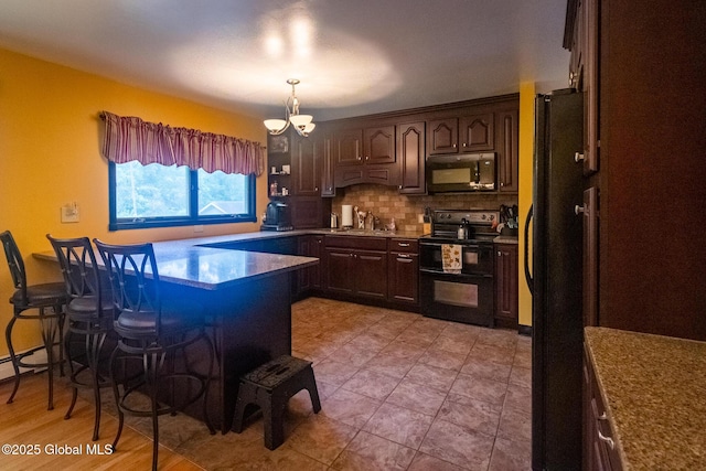 46 Cindy Crest Dr, Rotterdam, NY 12306 - kitchen with black appliances, a breakfast bar, a peninsula, and dark brown cabinets