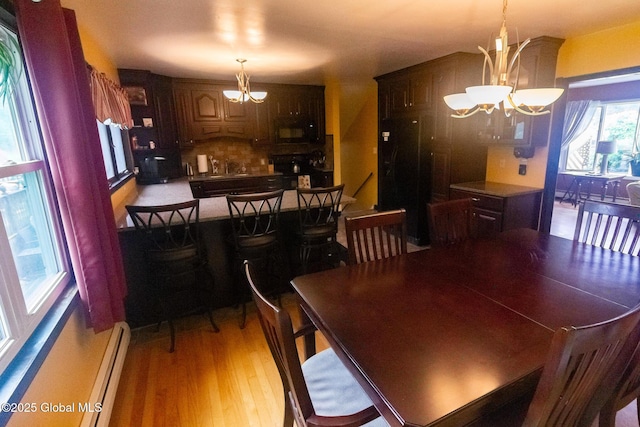 46 Cindy Crest Dr, Rotterdam, NY 12306 - dining area with a chandelier, wood finished floors, and baseboard heating