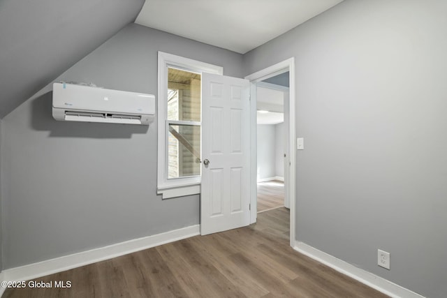 55 Spring Ave, Troy, NY 12180 - unfurnished bedroom featuring a wall unit AC, wood finished floors, and vaulted ceiling