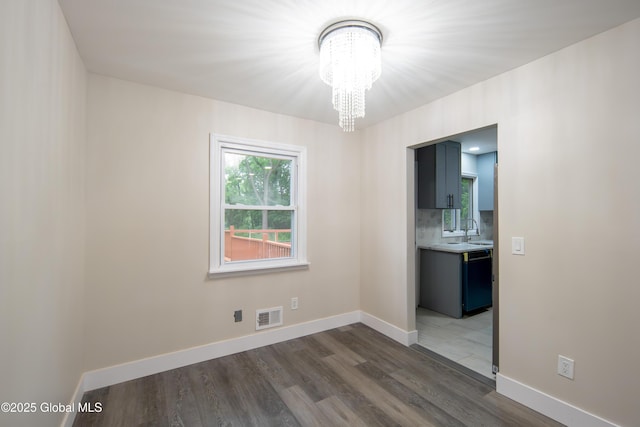 1041 Madison Ave, Troy, NY 12180 - spare room featuring a chandelier and dark wood-style flooring
