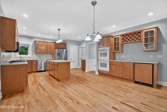 10 Sweetbriar Dr, Wilton, NY 12831 - kitchen with appliances with stainless steel finishes, light wood-style flooring, recessed lighting, glass insert cabinets, and ornamental molding