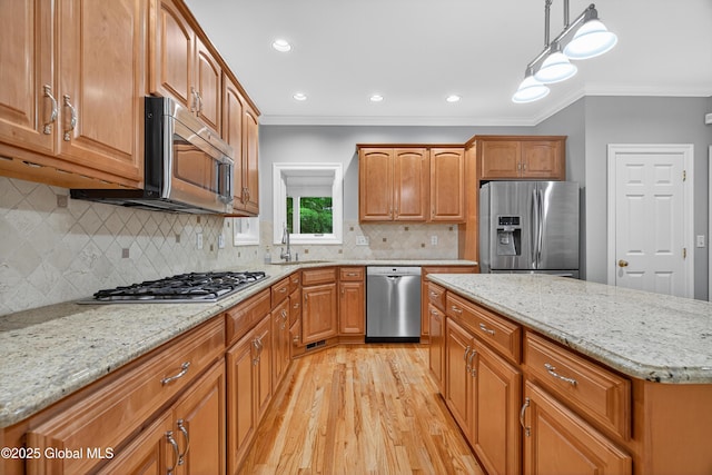 10 Sweetbriar Dr, Wilton, NY 12831 - kitchen with stainless steel appliances, ornamental molding, light wood finished floors, light stone countertops, and hanging light fixtures