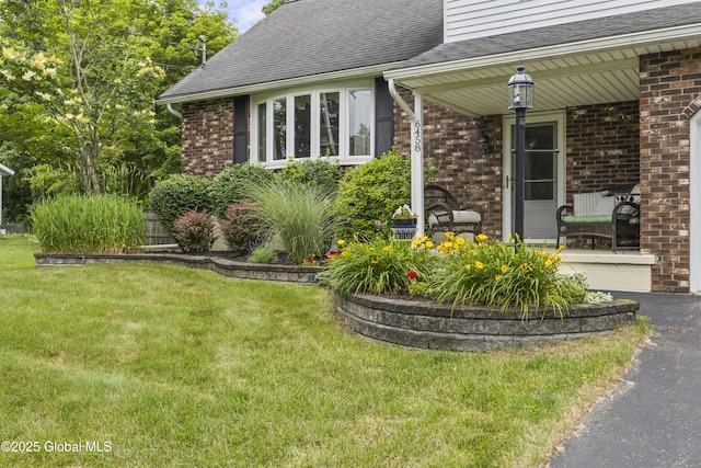 6458 Vosburgh Rd, Guilderland, NY 12009 - view of side of home with covered porch, brick siding, a shingled roof, and a lawn