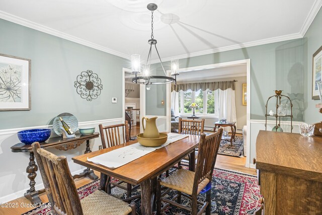 6458 Vosburgh Rd, Guilderland, NY 12009 - dining area featuring a chandelier, crown molding, wood finished floors, and a wainscoted wall