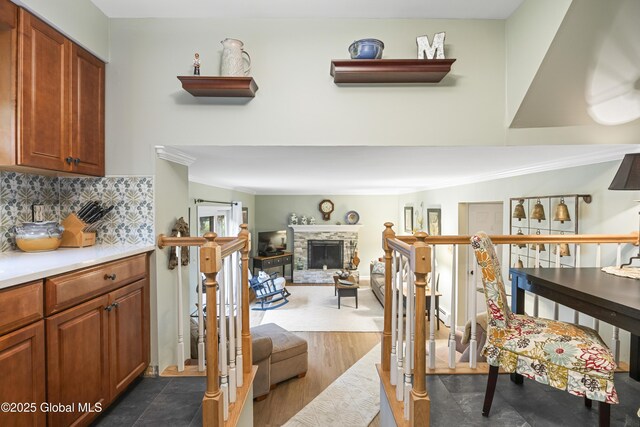 6458 Vosburgh Rd, Guilderland, NY 12009 - interior space with ornamental molding, decorative backsplash, light countertops, a fireplace, and brown cabinets