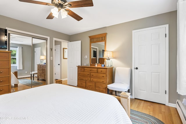 6458 Vosburgh Rd, Guilderland, NY 12009 - bedroom featuring baseboard heating, light wood-style floors, a ceiling fan, and a closet