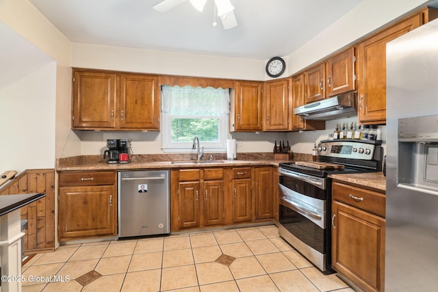 5012 Juniper Ln, Guilderland, NY 12303 - kitchen with stainless steel appliances, under cabinet range hood, brown cabinetry, a ceiling fan, and light tile patterned floors