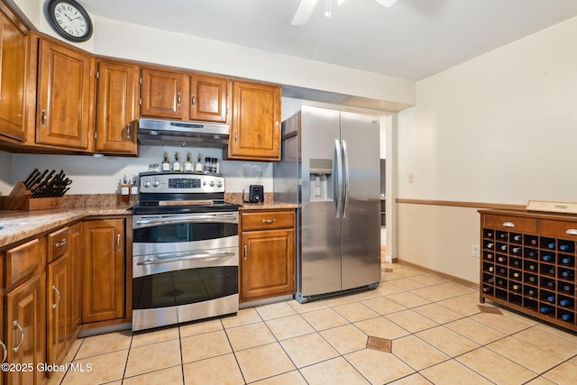 5012 Juniper Ln, Guilderland, NY 12303 - kitchen with stainless steel appliances, under cabinet range hood, brown cabinetry, a ceiling fan, and light tile patterned floors