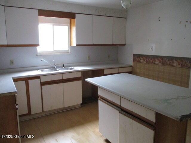 12 Chestnut St, Gloversville, NY 12078 - kitchen featuring white cabinetry, light countertops, and light wood-style floors