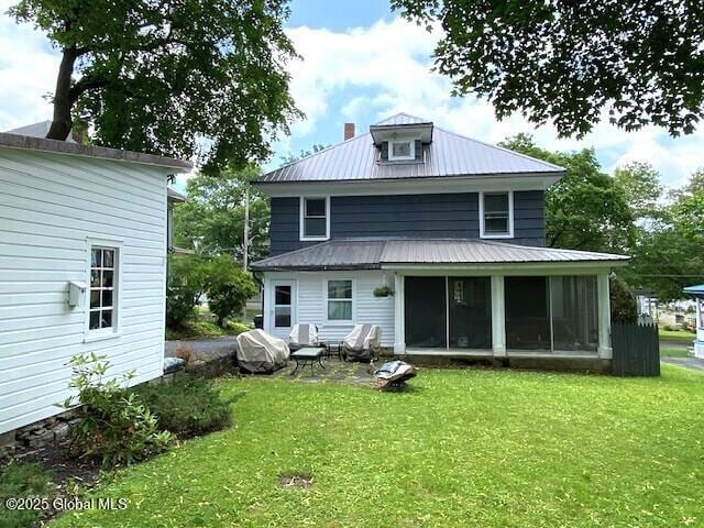 35 Walnut St, Canajoharie, NY 13317 - back of property featuring a metal roof, a sunroom, and a yard