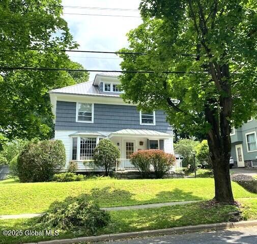 35 Walnut St, Canajoharie, NY 13317 - american foursquare style home with a front lawn and a metal roof