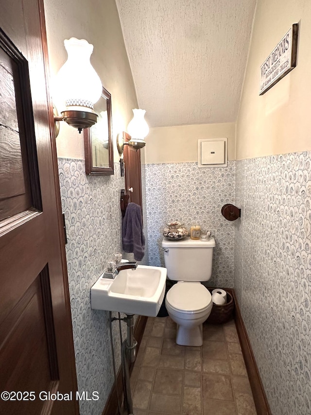 35 Walnut St, Canajoharie, NY 13317 - half bathroom with a textured ceiling, tile walls, and a wainscoted wall