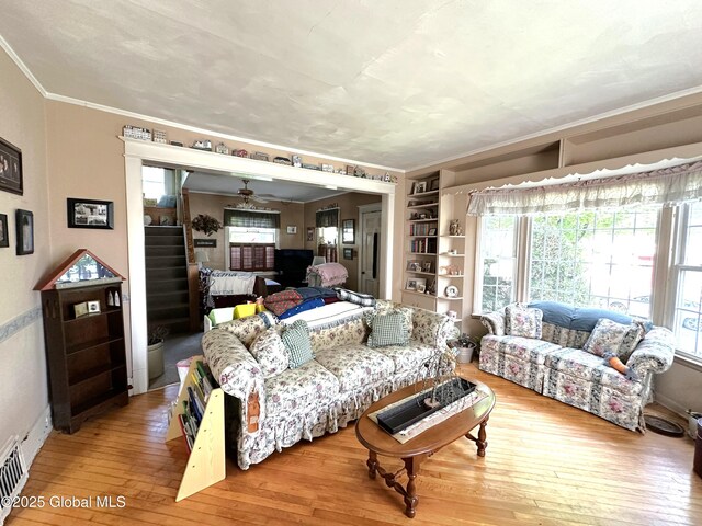 35 Walnut St, Canajoharie, NY 13317 - living room with ornamental molding, hardwood / wood-style floors, healthy amount of natural light, stairway, and built in shelves