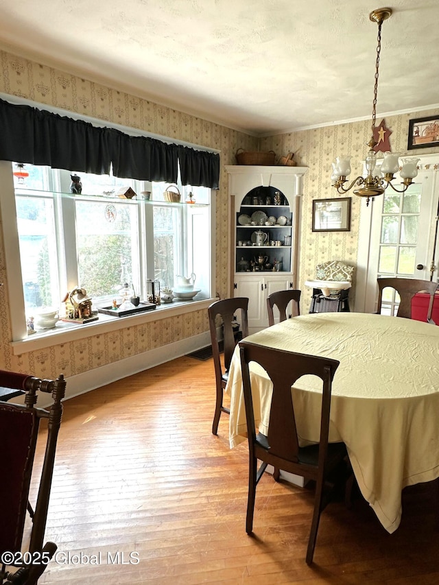 35 Walnut St, Canajoharie, NY 13317 - dining space featuring wallpapered walls, healthy amount of natural light, a chandelier, and light wood finished floors