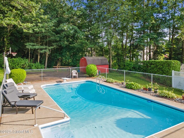 23 Tokay Ln, Colonie, NY 12309 - view of pool featuring a fenced backyard, a storage unit, view of wooded area, a patio area, and a diving board