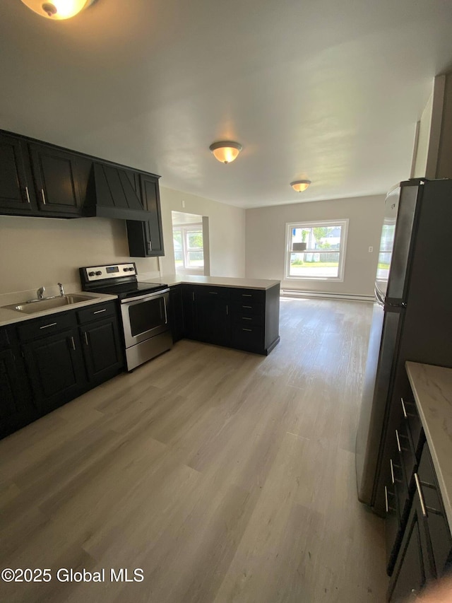 11 4th Ave, Whitehall, NY 12887 - kitchen featuring appliances with stainless steel finishes, dark cabinetry, light countertops, light wood-type flooring, and plenty of natural light