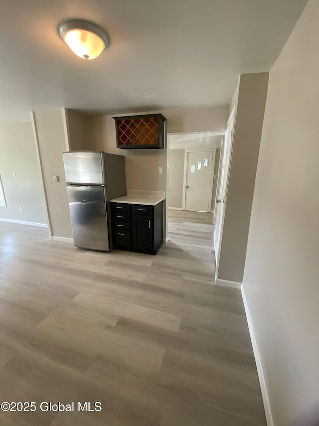 11 4th Ave, Whitehall, NY 12887 - kitchen with freestanding refrigerator, light wood-style flooring, light countertops, and dark cabinets