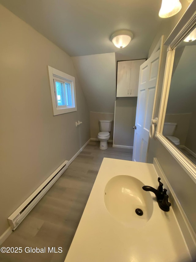 11 4th Ave, Whitehall, NY 12887 - bathroom featuring a baseboard heating unit, wood finished floors, vanity, and lofted ceiling