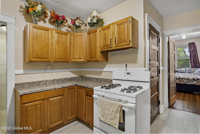 2303 Burdett Ave, Troy, NY 12180 - kitchen featuring gas range gas stove and brown cabinetry