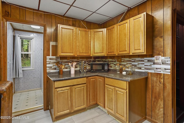 2303 Burdett Ave, Troy, NY 12180 - kitchen with black microwave, dark stone counters, light floors, and backsplash