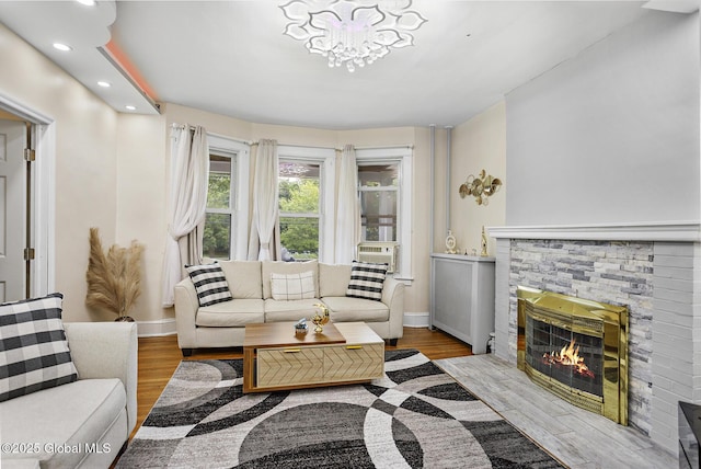 2303 Burdett Ave, Troy, NY 12180 - living area featuring recessed lighting, wood finished floors, a stone fireplace, a chandelier, and cooling unit