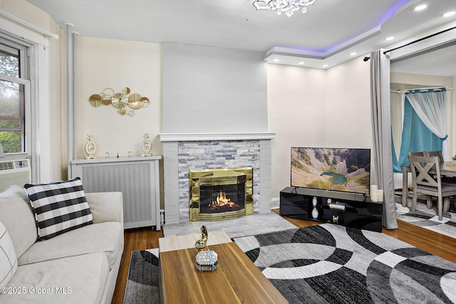 2303 Burdett Ave, Troy, NY 12180 - living room featuring wood finished floors, a stone fireplace, recessed lighting, and radiator heating unit