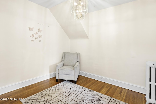 2303 Burdett Ave, Troy, NY 12180 - living area with radiator heating unit, a chandelier, and wood finished floors