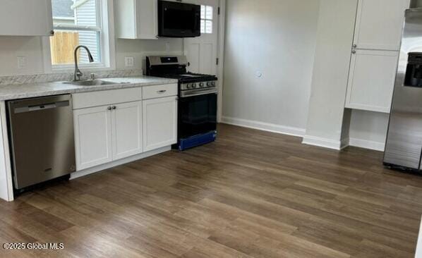 47 Chestnut St, Rensselaer, NY 12144 - kitchen featuring appliances with stainless steel finishes, white cabinets, light countertops, and dark wood-type flooring