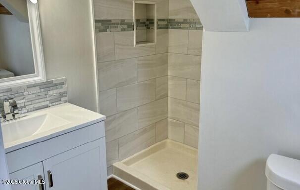 47 Chestnut St, Rensselaer, NY 12144 - bathroom with a tile shower, vanity, and decorative backsplash