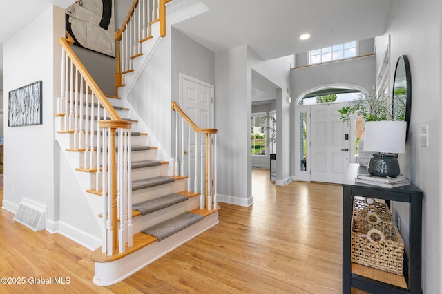 11 Fairview Ln, Halfmoon, NY 12118 - foyer entrance featuring wood finished floors, stairs, a high ceiling, and recessed lighting
