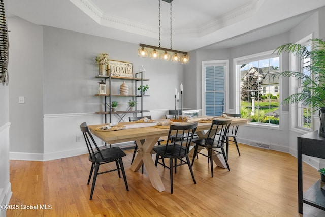 11 Fairview Ln, Halfmoon, NY 12118 - dining area featuring a tray ceiling, light wood-style flooring, and ornamental molding