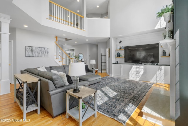 11 Fairview Ln, Halfmoon, NY 12118 - living area with stairway, wood finished floors, recessed lighting, a high ceiling, and ornate columns
