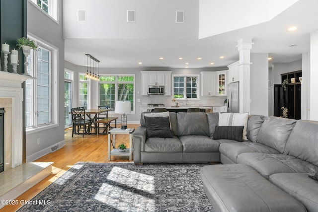 11 Fairview Ln, Halfmoon, NY 12118 - living area with healthy amount of natural light, light wood finished floors, a fireplace, a towering ceiling, and recessed lighting